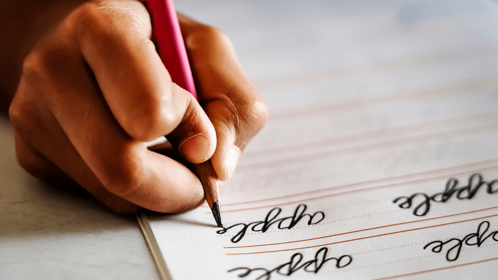 anak sedang berlatih menulis sambung atau cursive